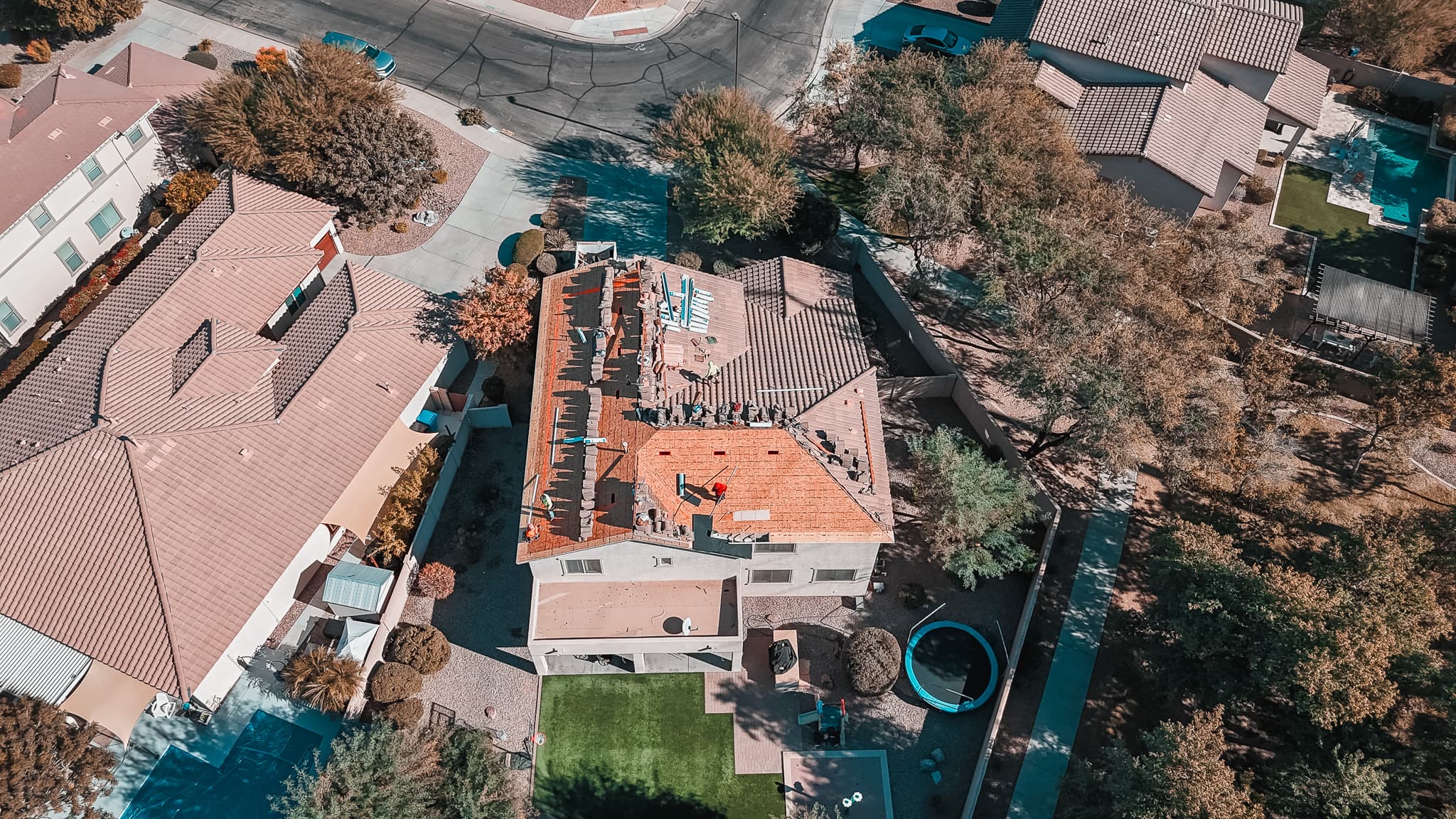 Aerial drone view of a Phoenix Valley tile-roof residential neighborhood served by HailCo Roofing