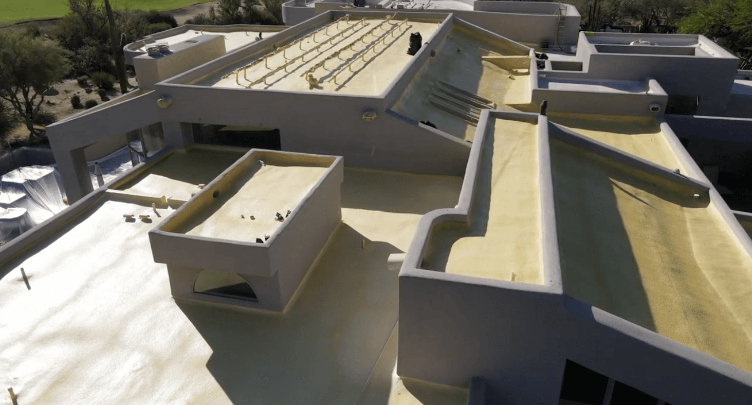 Close-up of the multi-level foam roof on the Desert Highlands estate, parapet walls and fresh spray foam over the existing low-slope sections